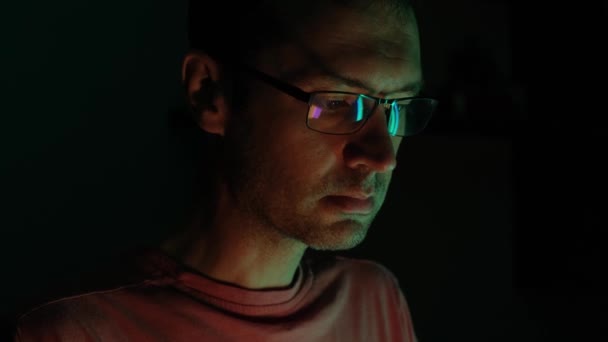 メガネを着て座って コンピュータのモニターを注意深く見て驚いた男性の閉じた肖像画 — ストック動画