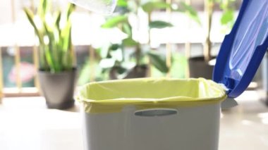 Plastik şişeyi çöp kutusuna atan bir adamın yakın çekimi..