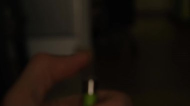 Karanlık arka planda yanan gaz çakmaklarını tutan taşınabilir bir cihaz alev yaratmak için kullanılıyor.