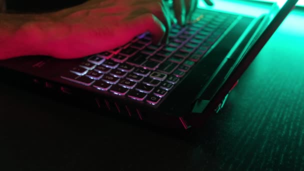 Een Mans Handtypen Een Laptop Toetsenbord Verlicht Neon Licht — Stockvideo
