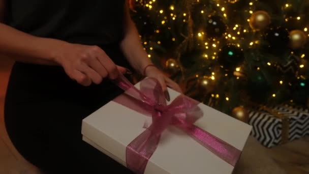 Een Meisje Trekt Een Lint Een Geschenk Tegen Achtergrond Van — Stockvideo