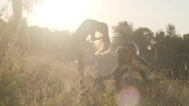 Una Chica Motociclista Con Una Motocicleta Contra Fondo Del Sol — Vídeos de Stock