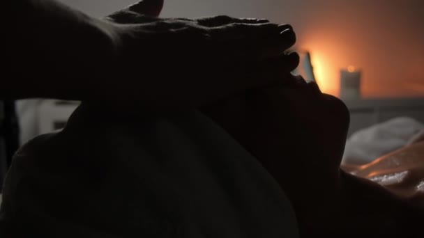 Bir Masör Mum Işığında Spa Salonundaki Genç Bir Kadına Yüz — Stok video