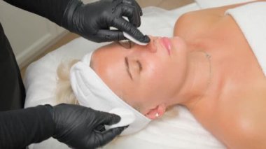 Kozmetik uzmanı, modellerin yüzünü pamukla temizler ve nemlendirir..