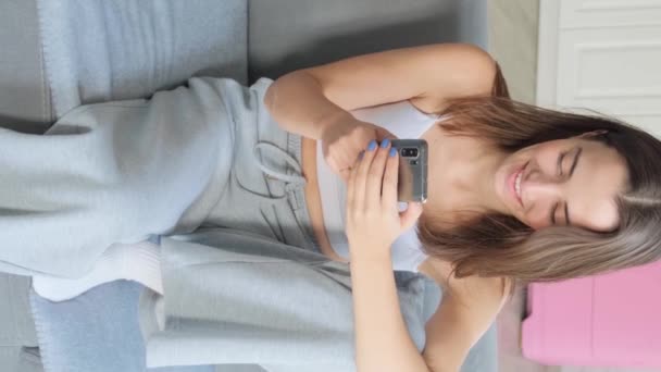 Vidéo Verticale Fille Est Assise Sur Canapé Sourit Parle Téléphone — Video