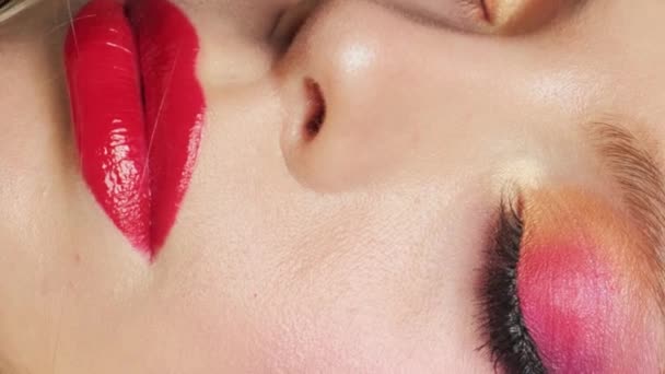 美丽的模特 妆容明亮 嘴唇红润 一个女孩在蓝色背景下的特写 垂直录像 — 图库视频影像