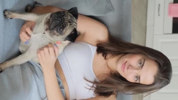Una Chica Sienta Sofá Con Perrito Retrato Cerca Vídeo Vertical — Vídeo de stock