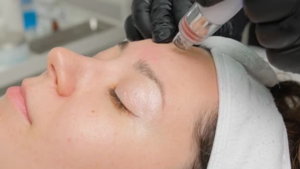 クローズアップ化粧品学者は 現代の診療所で患者の皮膚をきれいにし 若返らせるためにヒドローピング機械を操作する — ストック動画