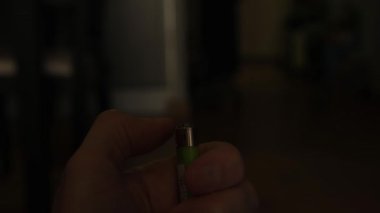 Karanlık arka planda yanan gaz çakmaklarını tutan taşınabilir bir cihaz alev yaratmak için kullanılıyor.