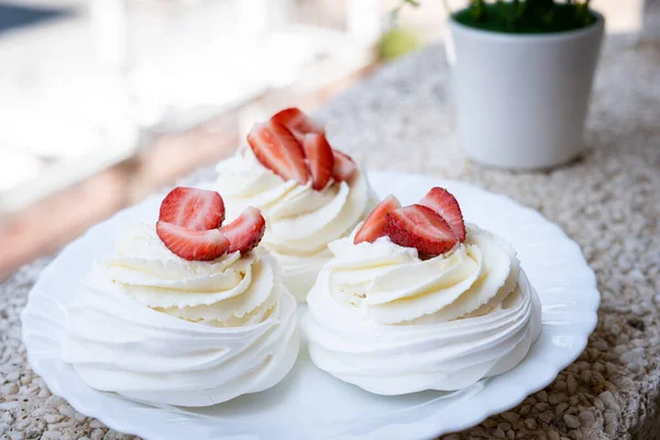 Homemade meringue dessert Pavlova cake with fresh strawberries and mint. Summer dessert. French cake. Confectionery. Classic dessert. Strawberry dessert