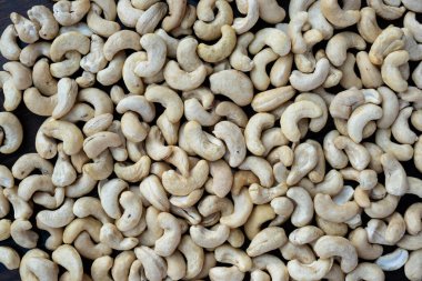 Ahşap bir masanın üzerinde çiğ kaju fıstığı..