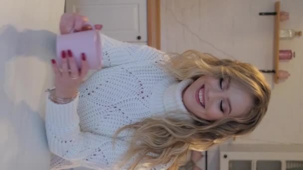 暖かいセーターと紅茶のカップの美しいブロンド クローズアップポートレート バーティカルビデオ — ストック動画