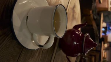 Tahta bir masada bir fincan sıcak çay. Dikey video.