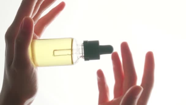 Prachtige Vrouwenhanden Houden Cosmetische Olie Vast Een Doorzichtige Witte Fles — Stockvideo