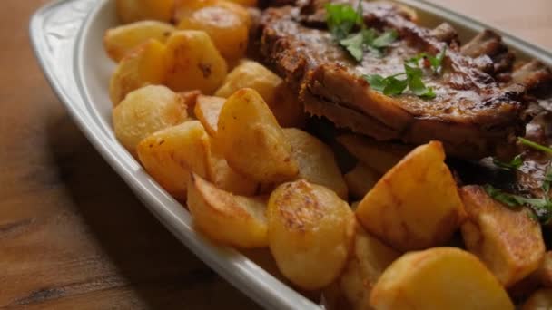 Ein Gericht Mit Kartoffeln Und Schweinerippchen Auf Einem Holztisch Großaufnahme — Stockvideo