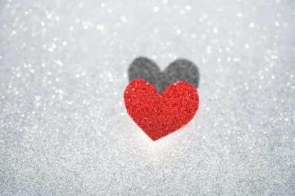 Red heart on a silver background with beautiful bokeh. Valentines Day is the feast of lovers.
