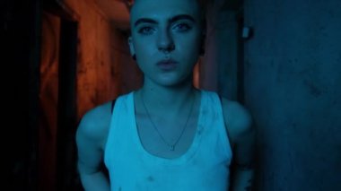 Uyuşturucu bağımlısı kel bir kadın uyuşturucu kullanmadan yoksunluk belirtileri gösterir. Neon ışıklı eski bodrum katı. Umutsuz uyuşturucu bağımlısı