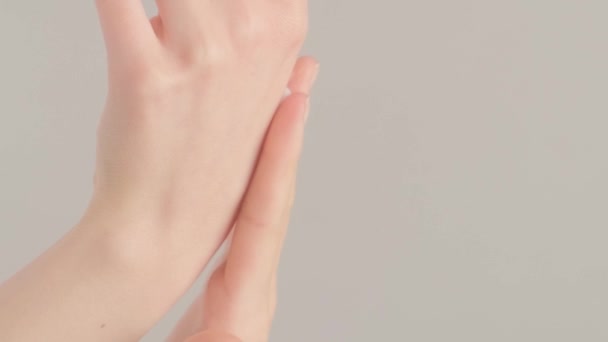 一个女人把药水从吸盘上滴落在她的手掌上 擦着化妆品油 在灰色背景上的密切合作 垂直录像 — 图库视频影像