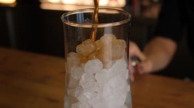 Bir barmen yakın planda Küba Libre kokteyli hazırlıyor..