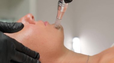 Güzellik uzmanının cilt bakımı sırasında güzel bir kadının yakın plan portresi..