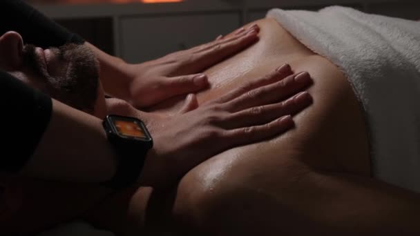烛光下 在一间昏暗的房间里为一个在温泉沙龙里的男人放松胸部和颈部按摩 — 图库视频影像