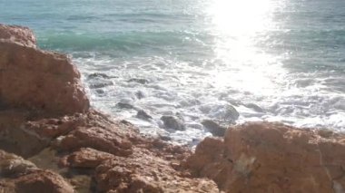 Deniz dalgaları taşların üzerinde yuvarlanıyor