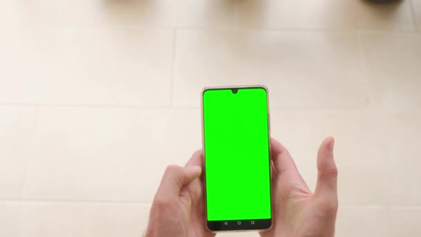 Een Man Houdt Een Telefoon Zijn Handen Met Een Groen — Stockvideo