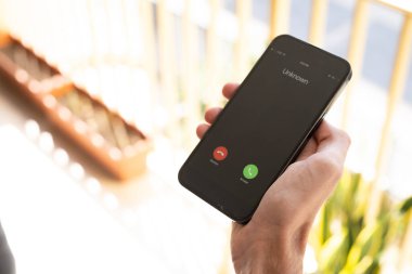 Dolandırıcılık ya da sahtekarlık. Bilinmeyen bir telefondan gelen beklenmedik bir aramanın olduğu bir erkek elin yakın çekimi.