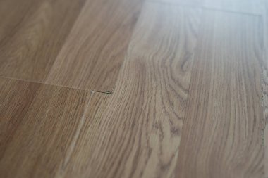 Laminate flooring with visible defects like chips, cracks, and unevenness. clipart