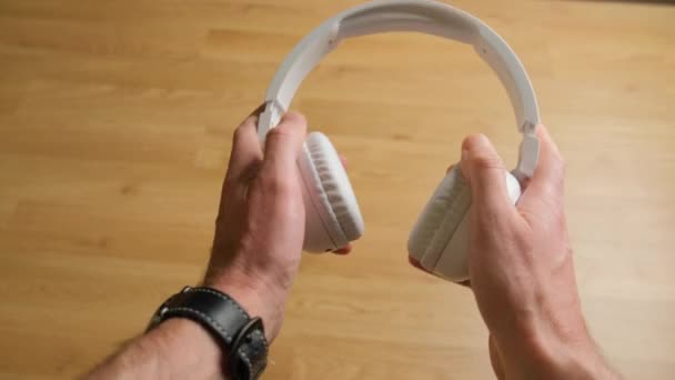 Чоловік Тримає Білі Бездротові Навушники Руках — стокове відео