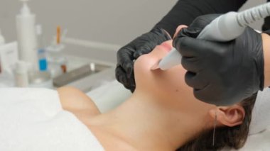Beautiful woman receiving ultrasound cavitation facial peeling. Cosmetology and facial skin care