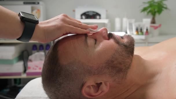 男人化妆品 在温泉中心用棉垫洗脸 一个留着胡子的男人的脸 — 图库视频影像
