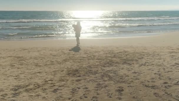 Mała Dziewczynka Plaży Tle Morza Biegnie Białym Małym Psem — Wideo stockowe