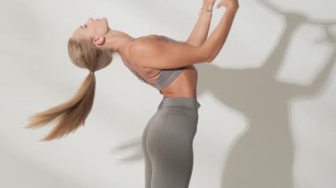 Beyaz arka planda, gölgeli akrobatik bir yüzükteki kız jimnastikçi..