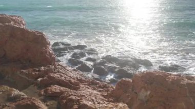 Deniz dalgaları taşların üzerinde yuvarlanıyor