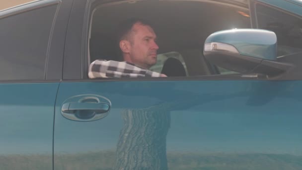 Mężczyzna Siedzi Samochodzie Wyrzuca Śmieci Przez Okno — Wideo stockowe