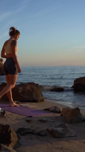 瞑想のための鋭い釘 サドゥーの木板の上に女性の足を踏みます 海の背景に対するヨガの練習 バーティカルビデオ — ストック動画