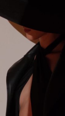 Stüdyoda altın madalyalı siyah şapkalı bir kızın moda portresi. Mücevherler. Dikey video.