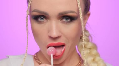 Kırmızı dudaklı güzel bir kadın model Eşofman altı yiyor lolipop kızı şeker yalıyor.