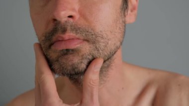 Traş olmadan önce banyoda sakallı bir adamın yakın çekimi..