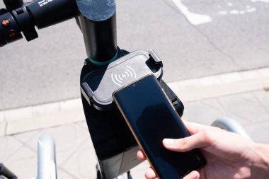 Tarragona, İspanya - 12 Haziran 2022: Elektrikli scooter kiralamak için QR kodlu direksiyon.