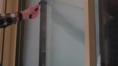 Bir adam pencereleri yakın plan temizler..