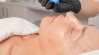 Güzellik uzmanının cilt bakımı sırasında güzel bir kadının yakın plan portresi..