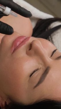 Bir kadının burnunun yanında şırınga, burun şeklini düzeltmek için dolgu malzemesi..