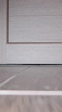 Bir yerleşim bölgesinde yangın. Kapının altından duman tütüyor. Dumanlı odalı bir dairede yangın. Dikey video.