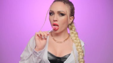 Kırmızı dudaklı güzel bir kadın model Eşofman altı yiyor lolipop kızı şeker yalıyor.