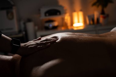 Kadın masöz, spa salonundaki adama profesyonel sırt masajı yapıyor..