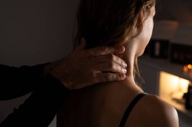 Bir kadının boynuna lenfatik drenaj masajı yapan erkek ellerinin yakın çekimi..