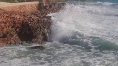 Deniz dalgaları taşların üzerinde yuvarlanıyor