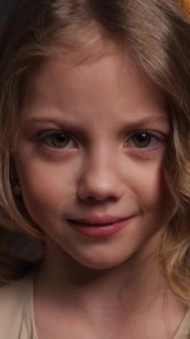 Küçük kız şaşırdı. Stüdyoda karanlık bir arka planda yakın plan portresi..